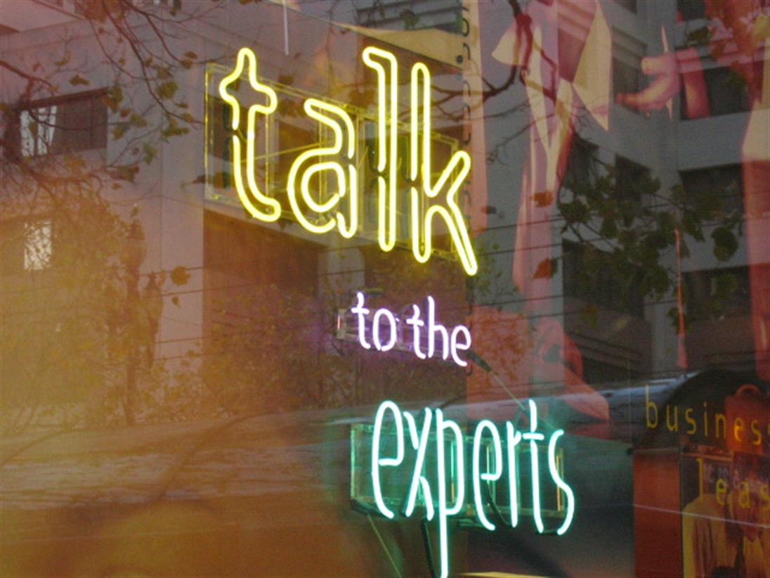 Text in Neonschrift "Talk to the Experts"