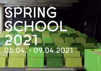 Das Bild zeigt einen Hörsaal mit vielen grünen Stühlen. Darüber steht in weiß "Spring School 2021 - 06.04. - 09.04.2021".